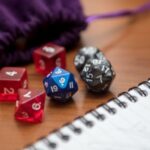 a pen, notebook, and dice in a purple velvet pouch to play a role-playing game like Dungeons and Dragons