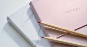 Closeup Photo of Journal Book and Pencils